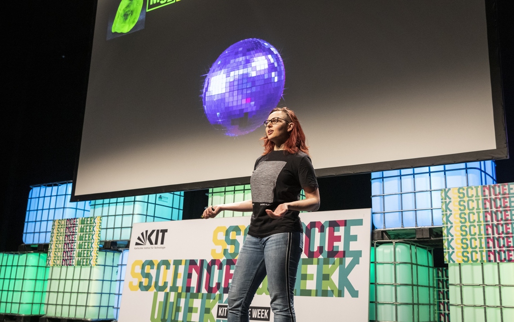 Weibliche Forscherin auf der Bühne während eines Science Slams