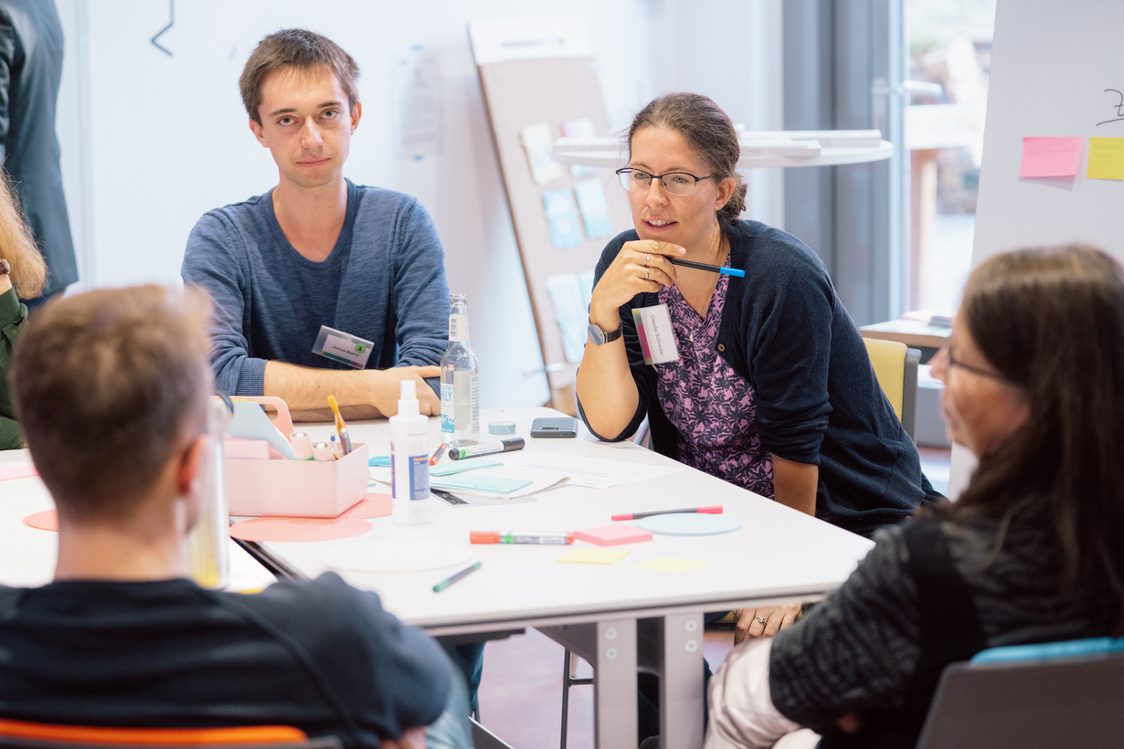 Menschen diskutieren am Tisch