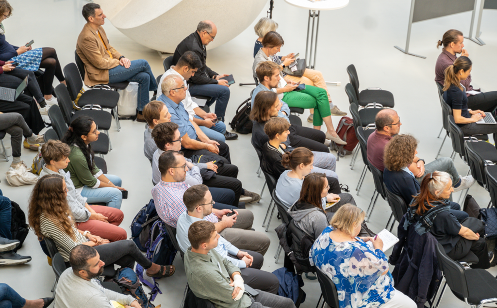Menschen sitzend bei der Konferenz der KIT Science Week 2023